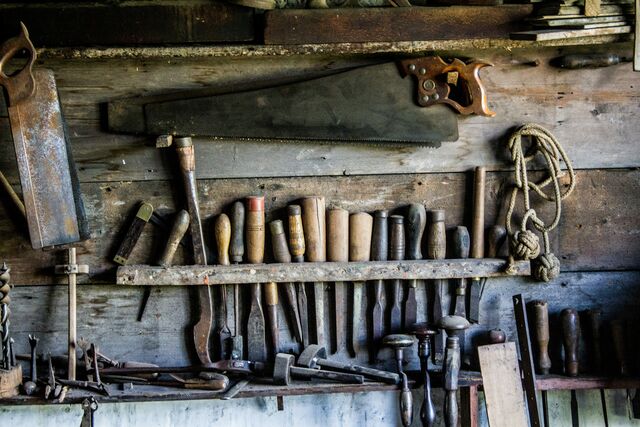 Old wookdworking tools hanging on a wall.